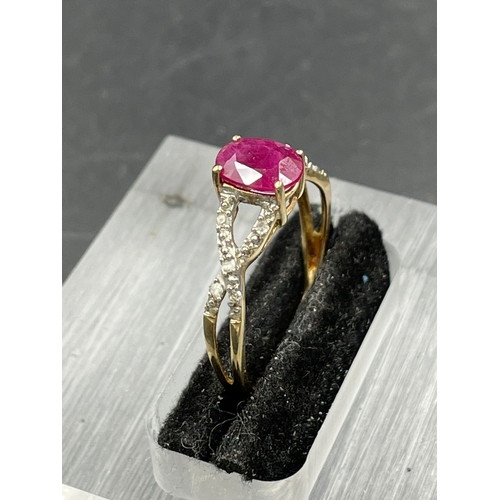 438A - A ruby and diamond ring, oval cut ruby weighing a calculated, with ten round cut diamonds set to the... 