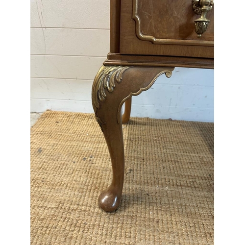 104 - A bow fronted dressing table with galleried top and brass drop handles on cabriole legs (H84cm W130c... 