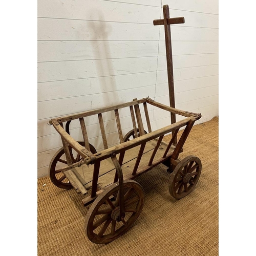 111 - A vintage wooden garden trolley on wooden metal bound wheels (H55cm W80cm D56cm)