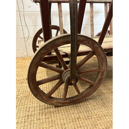 111 - A vintage wooden garden trolley on wooden metal bound wheels (H55cm W80cm D56cm)