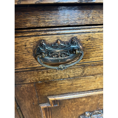 130 - Oak sideboard with carved crest detail to front (H90cm W130cm D50cm)