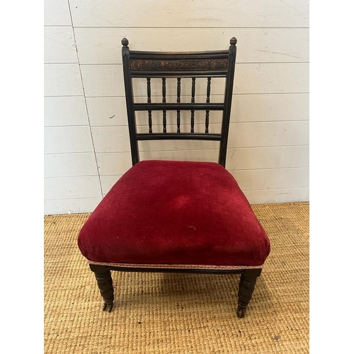 133 - A Victorian dark wood bedroom chair on castors with red upholstered seat AF