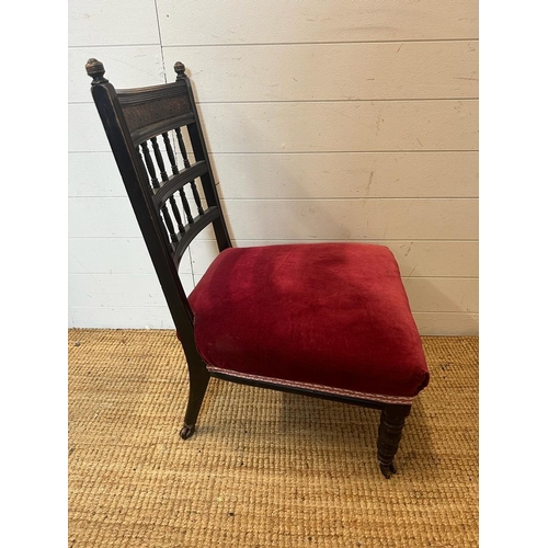 133 - A Victorian dark wood bedroom chair on castors with red upholstered seat AF