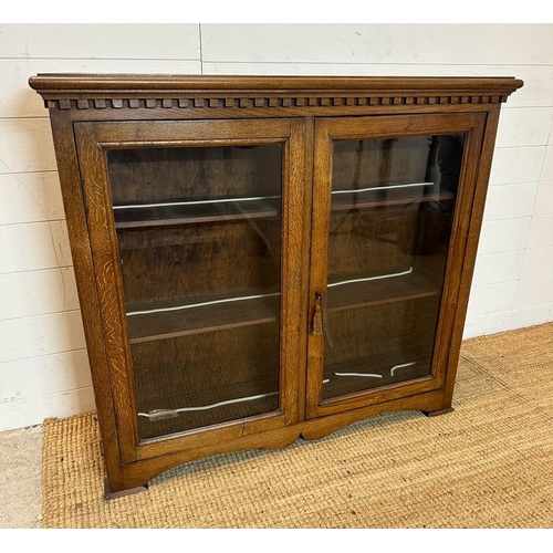 152 - An oak glazed lockable bookcase with key (H95cm W107cm D28cm)