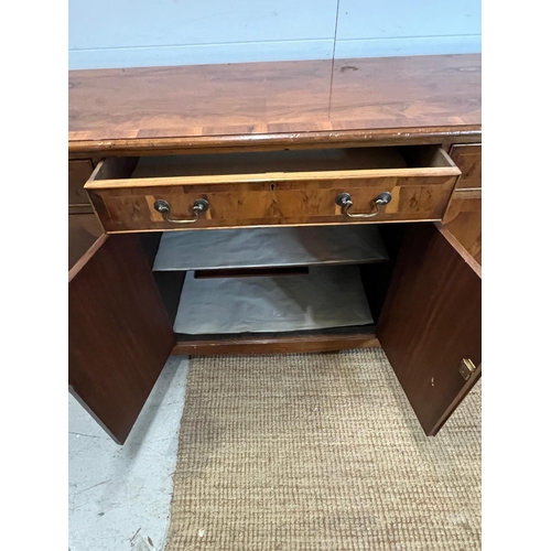 169 - A yew sideboard with double doors opening to shelves flanked by cupboards and drawers above (H80cm W... 