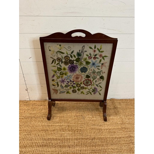 181 - A glass fronted mahogany fire screen with a floral tapestry insert