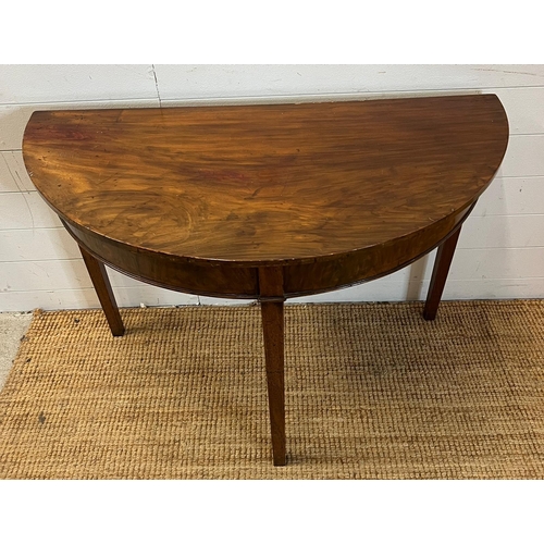 183 - A Demi Lune mahogany table on tapering legs (H74cm W108cm D51cm)