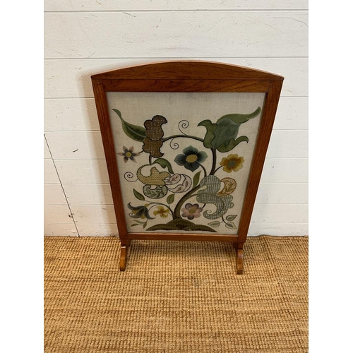 187 - A light oak framed fire screen with glazed front and floral tapestry insert