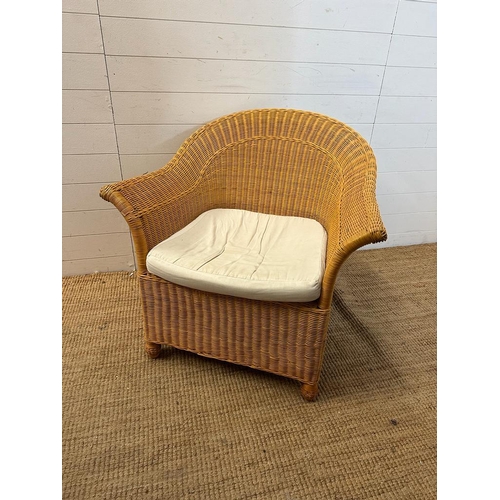 206 - A wicker arm chair with white upholstered seat cushion