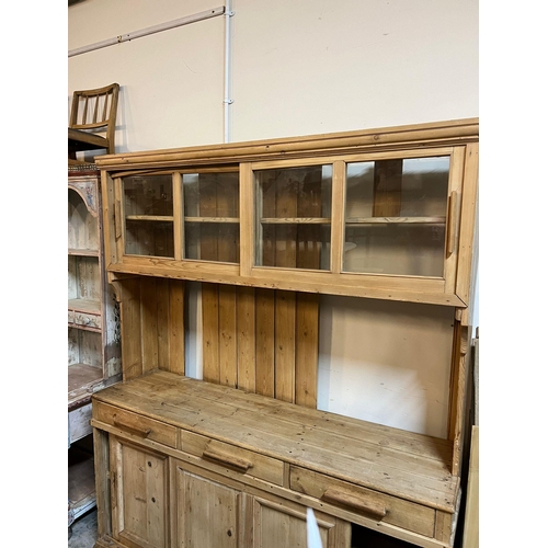 209 - A pine dresser with sliding glazed doors to top, plate rack and sliding doors to base (H202cm W167cm... 