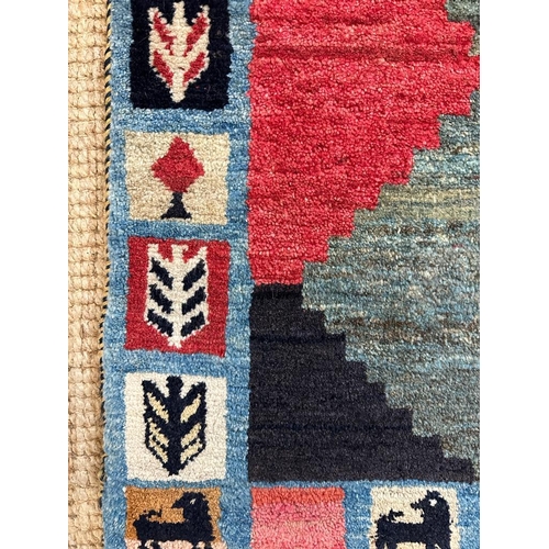 218 - A hand knotted nomad rug in greens, reds and blues 153cm x 80cm