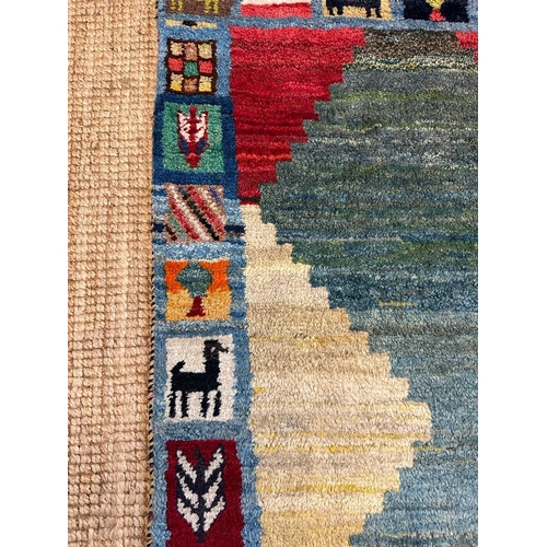 218 - A hand knotted nomad rug in greens, reds and blues 153cm x 80cm