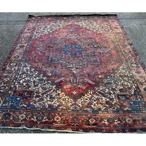 226 - A large red ground rug with central star medallion 360cm x 262cm