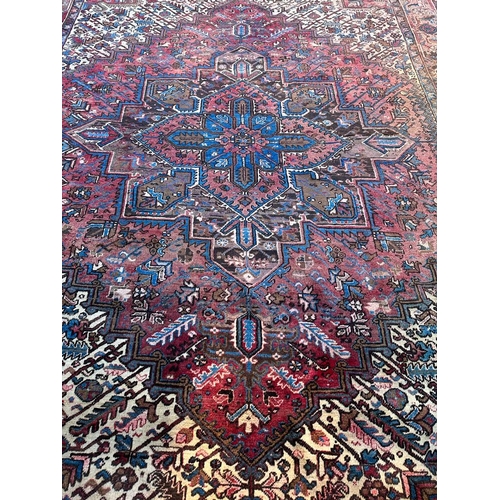 226 - A large red ground rug with central star medallion 360cm x 262cm