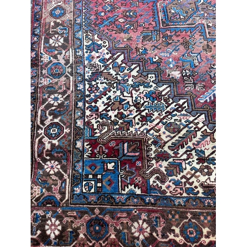 226 - A large red ground rug with central star medallion 360cm x 262cm