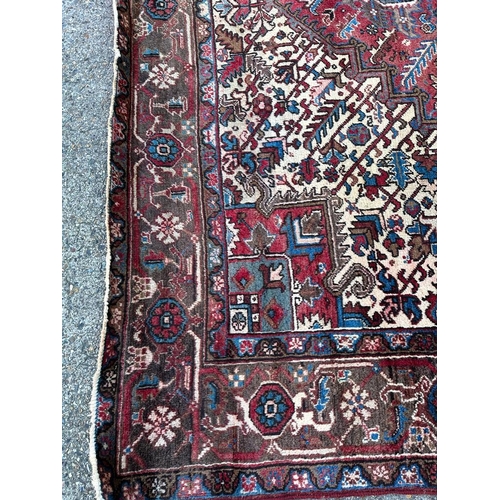 226 - A large red ground rug with central star medallion 360cm x 262cm