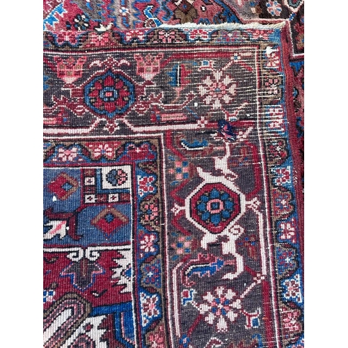 226 - A large red ground rug with central star medallion 360cm x 262cm