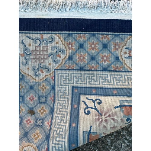 228 - A large beige ground rug with a blue boarder and central medallion 276cm x 386cm