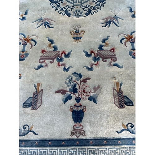 228 - A large beige ground rug with a blue boarder and central medallion 276cm x 386cm