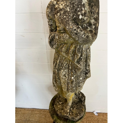 258 - A weathered cast stone statue of a maiden with her arms clasped on a fluted circular base (H83cm Bas... 