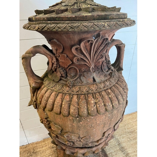 259 - A terracotta stone garden urn of amphora form and scrolling handles (H160cm W66cm)