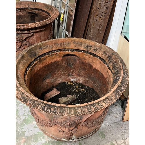 266 - A pair of ornamental terracotta urns with classical style, decorated with a floral laurel joined by ... 