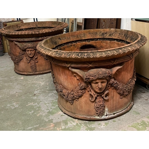 266 - A pair of ornamental terracotta urns with classical style, decorated with a floral laurel joined by ... 