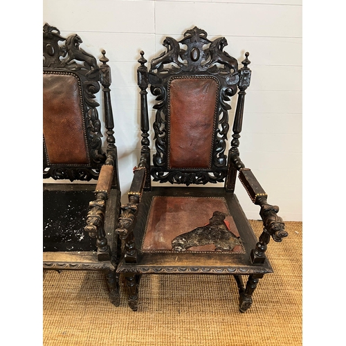 293 - A pair of oak throne chairs, gothic hall chairs with carved swags and scrolls, flanked by tapering c... 