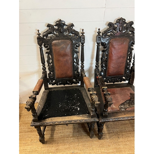 293 - A pair of oak throne chairs, gothic hall chairs with carved swags and scrolls, flanked by tapering c... 