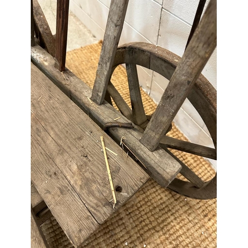 353 - A vintage wooden dog cart or garden trolley with metal bound wheels