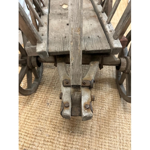 353 - A vintage wooden dog cart or garden trolley with metal bound wheels