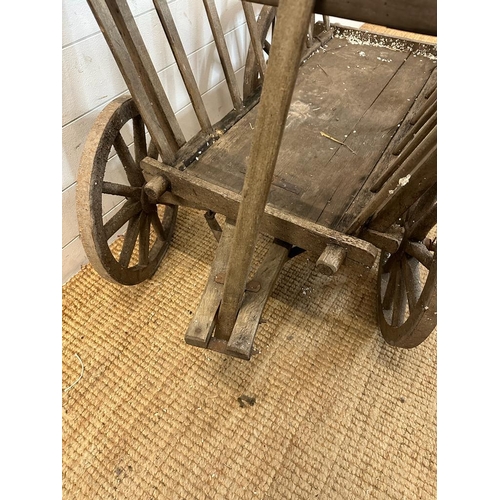 355 - A vintage wooden dog cart or garden trolley with metal bound wheels