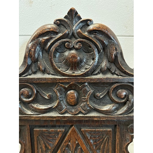 36 - A single oak Jacobean style hall chair with a carved lion back and turned supports finishing in deco... 