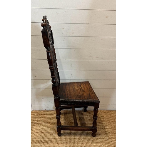 36 - A single oak Jacobean style hall chair with a carved lion back and turned supports finishing in deco... 