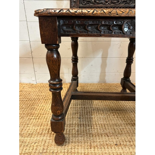 36 - A single oak Jacobean style hall chair with a carved lion back and turned supports finishing in deco... 