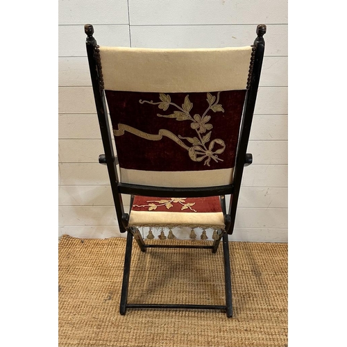 37 - A lacquered wooden folding campaign chair with red and white floral seat and back