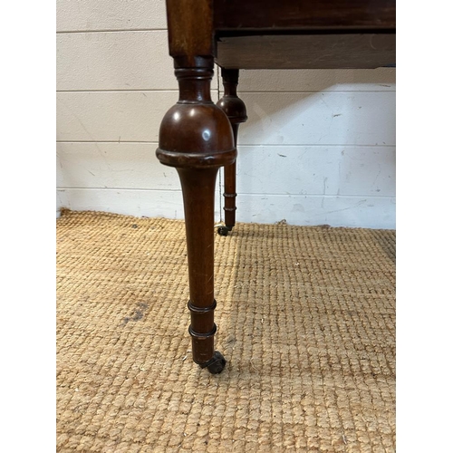 41 - A mahogany knee hole dressing table with central drawer flanked by two shorter drawers, turned legs ... 