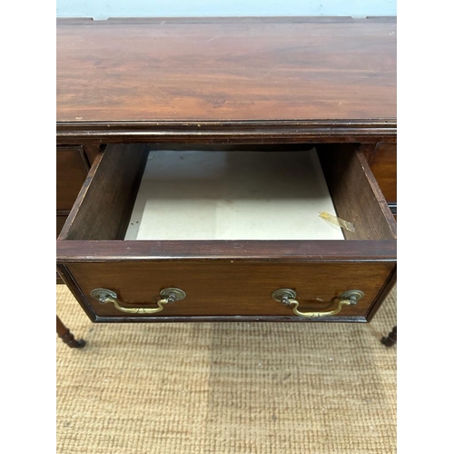 41 - A mahogany knee hole dressing table with central drawer flanked by two shorter drawers, turned legs ... 