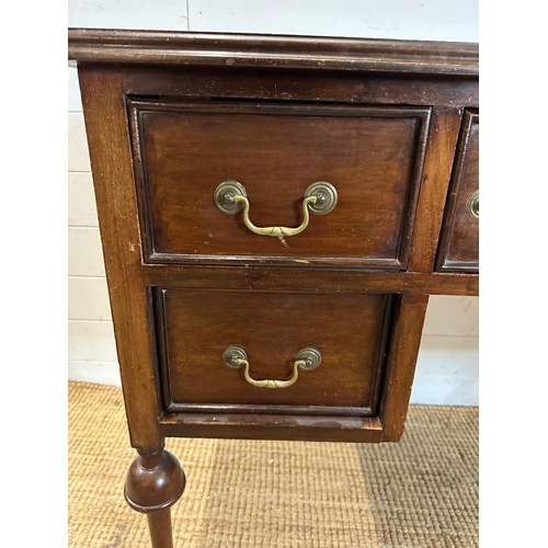 41 - A mahogany knee hole dressing table with central drawer flanked by two shorter drawers, turned legs ... 