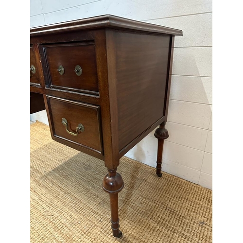 41 - A mahogany knee hole dressing table with central drawer flanked by two shorter drawers, turned legs ... 