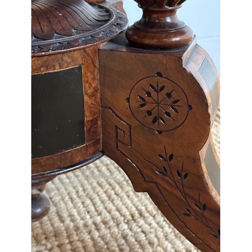 42 - An oval walnut centre table with ebonised inlay and pierced floral detail, on four splayed legs with... 