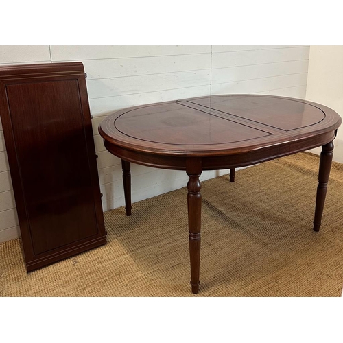 43 - An extendable oval mahogany dining table with brass string inlay on turned legs with an accompanying... 