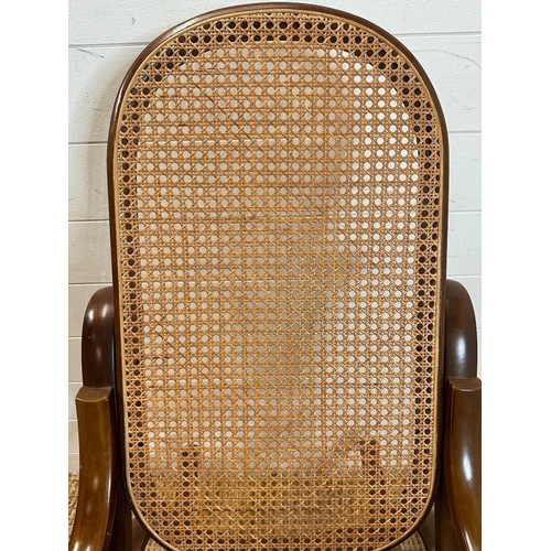 44 - A scrolling Bentwood rocking chair with rattan back and seat