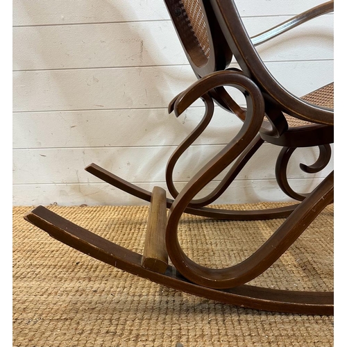 44 - A scrolling Bentwood rocking chair with rattan back and seat