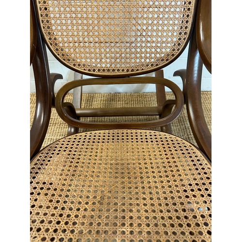 44 - A scrolling Bentwood rocking chair with rattan back and seat