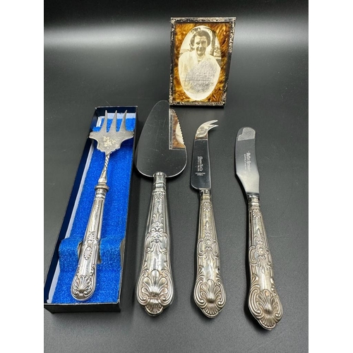 473 - A small selection of silver handled flatware and a silver framed photo frame.