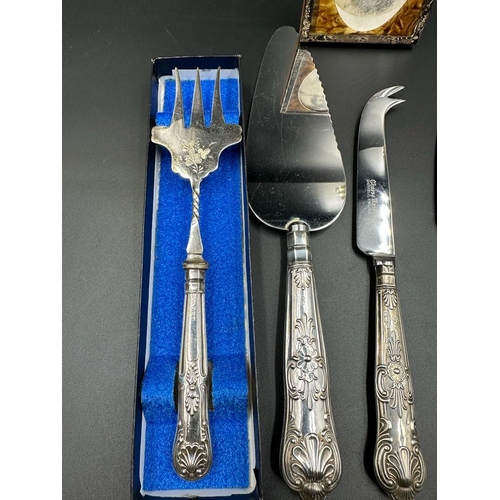 473 - A small selection of silver handled flatware and a silver framed photo frame.