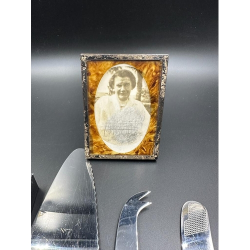 473 - A small selection of silver handled flatware and a silver framed photo frame.