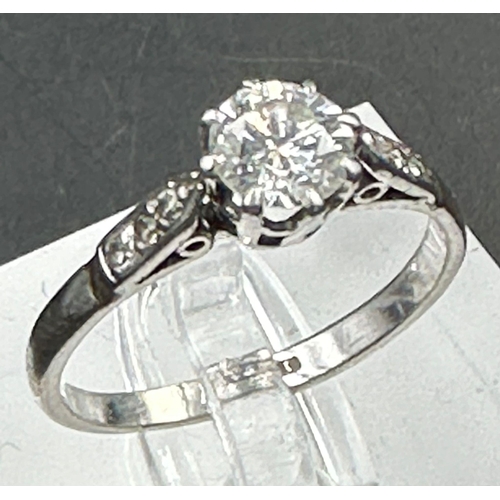 558 - A single stone diamond ring with diamond set shoulders. Round Brilliant cut diamond 0.64ct, Colour F... 