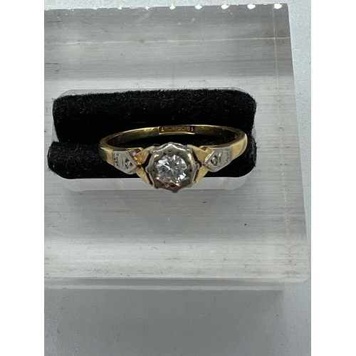 595 - An 18ct and platinum set diamond ring with central stone and shoulders Size M